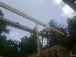 Carpenter setting a ridge beam over a new addition frame — Ice Dam Removal by Roofing Brothers in Broad Brook