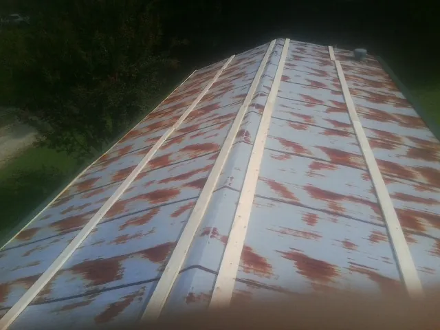 Rusted metal roof panels with new wood purlins before replacement — Storm Damage Roof Repair in Broad Brook by Roofing Brothers