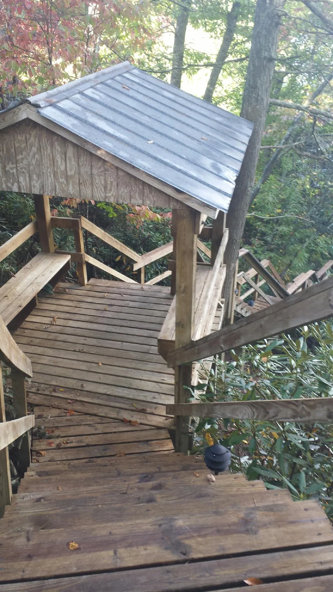 Metal roofed shelter over wooden steps on a wooded walkway — Skylight Repair & Installation work by our crew in Broad Brook