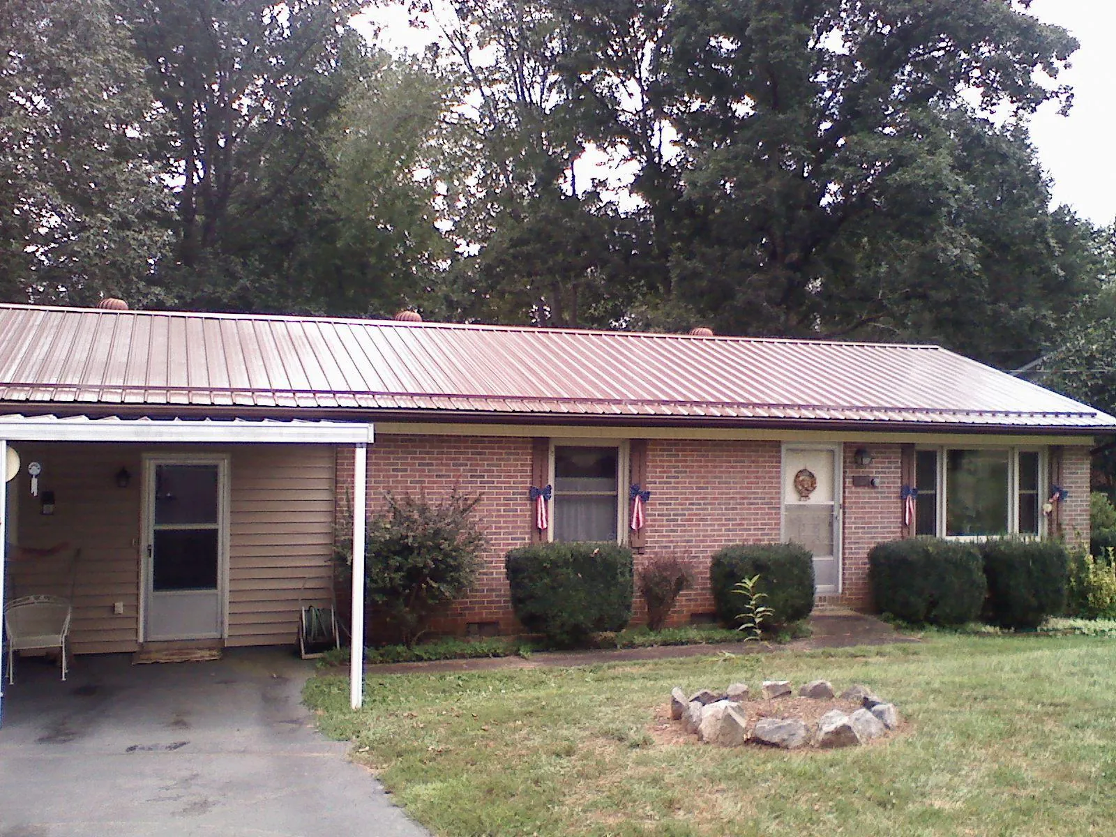 Bronze metal roof and carport on a brick ranch home — Roof Repair work by our crew in Broad Brook